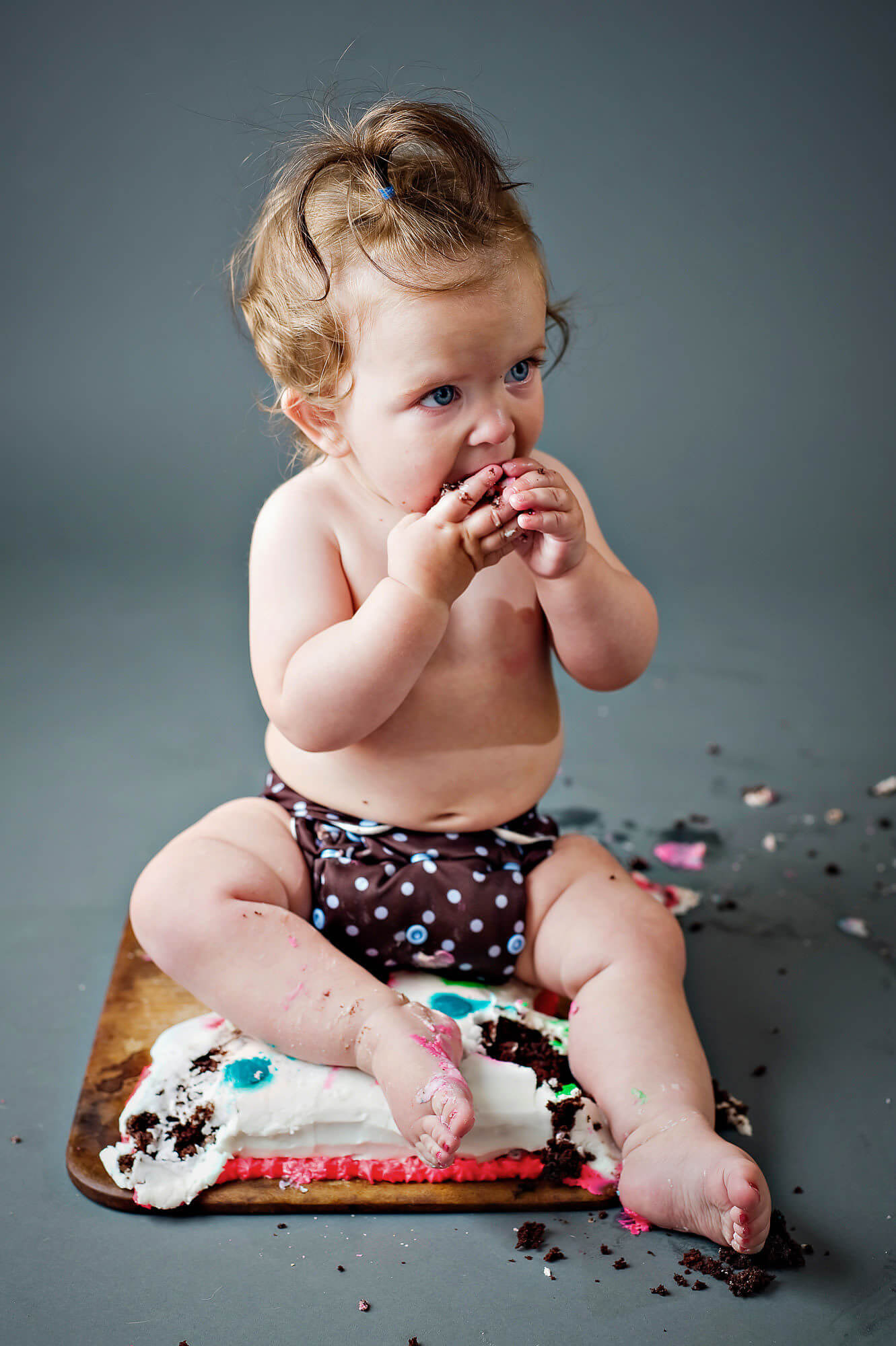 Portrait of a cute baby eating cake by Nick Perry Photography