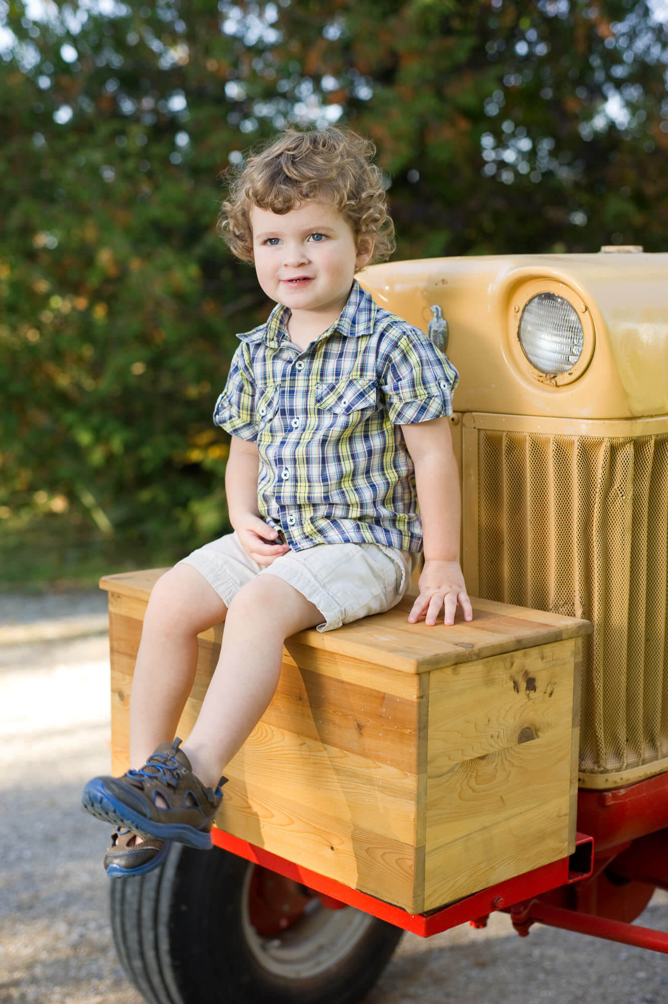 Portrait of a young boy sitting on a tractor by Nick Perry Photography