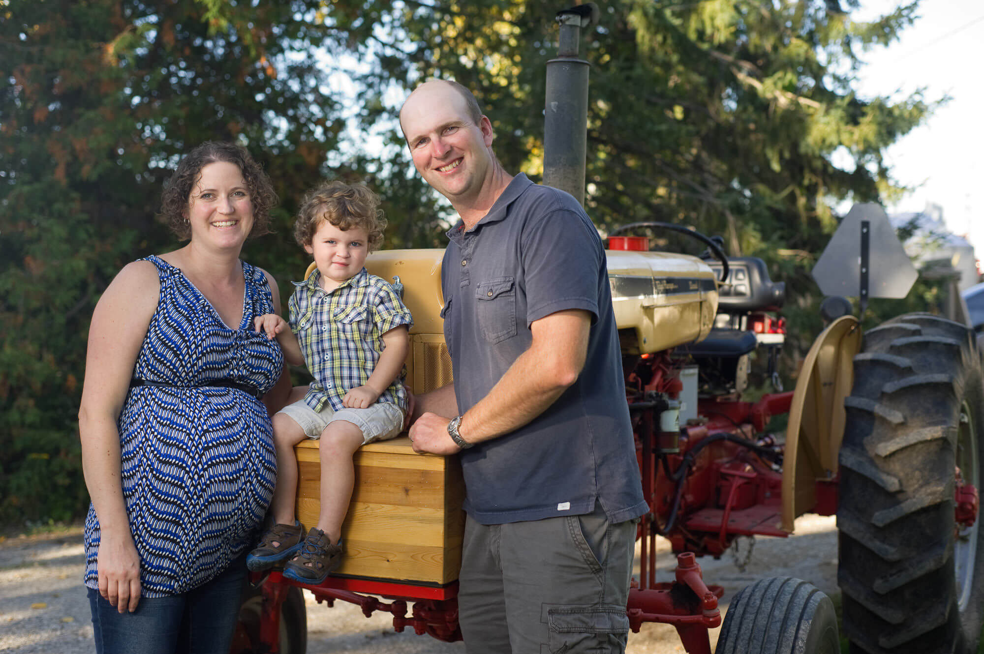 Photo of mother, father and young boy sitting on a tractor by Nick Perry Photography