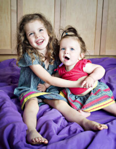 Portrait of two young sisters hugging each other by Nick Perry Photography