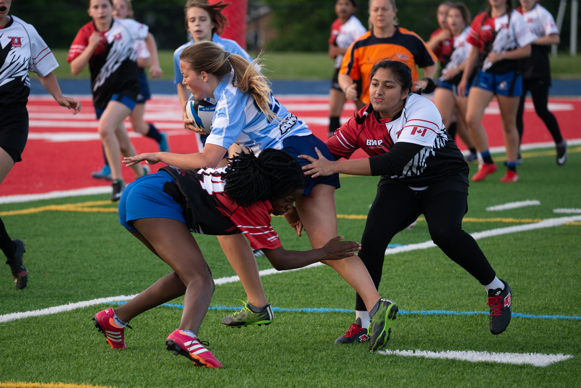Girls rugby player running with ball
