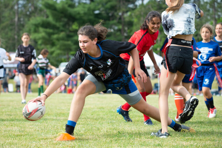 Female rugby athlete reaching for the ball